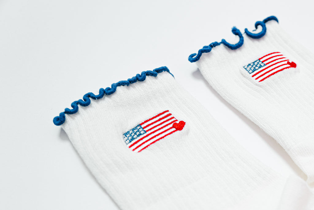 Socks with american flag design with small heart in the corner and navy blue ruffle tops