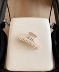 Cream claw clip with brown text saying “save a horse, ride a reformer” on a white reformer background 