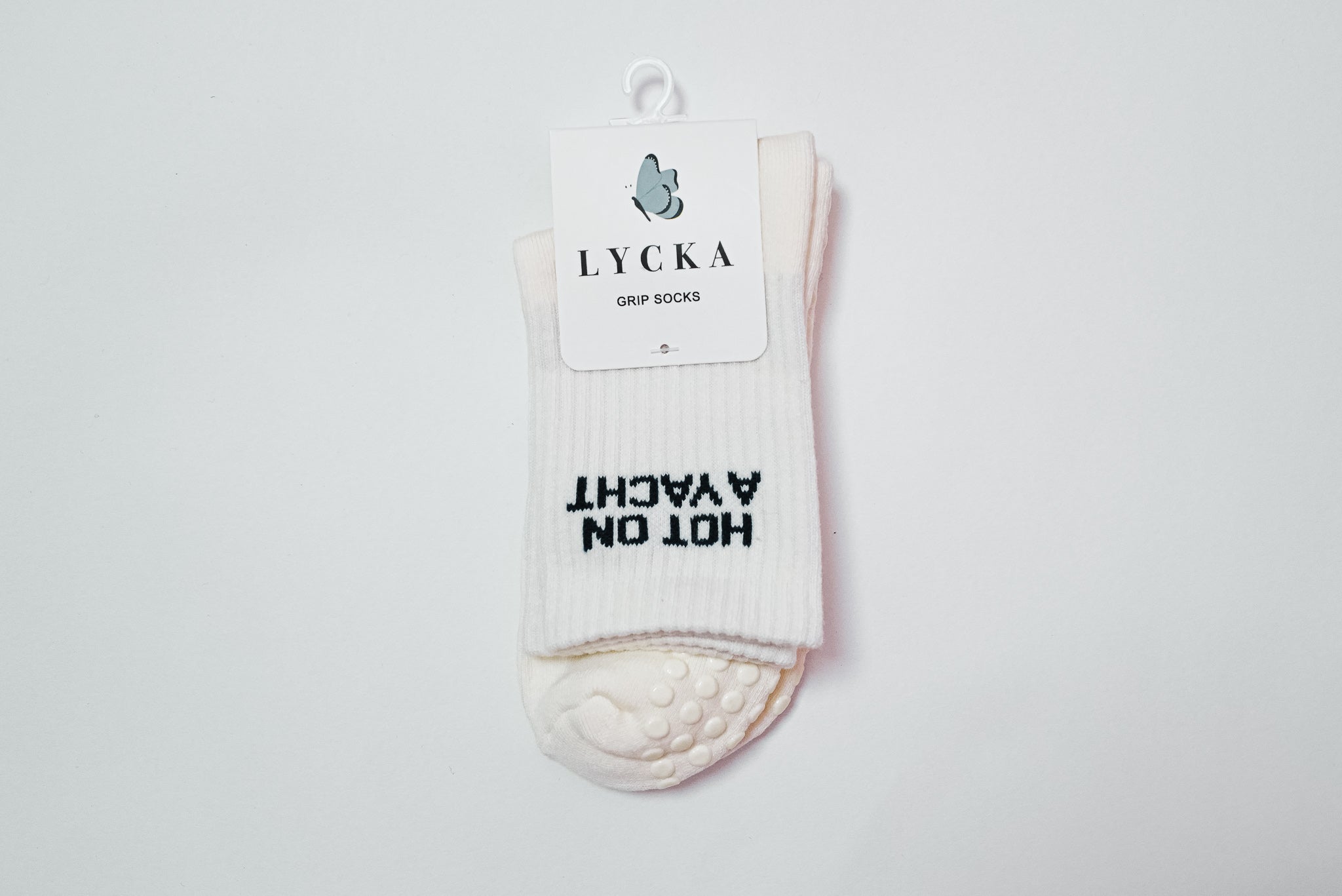 White socks with text "hot on a yacht" on a white background, featuring the brand 'LYCKA'.