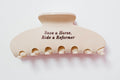 Cream hair clip with text 'Save a Horse, Ride a Reformer' on a white background